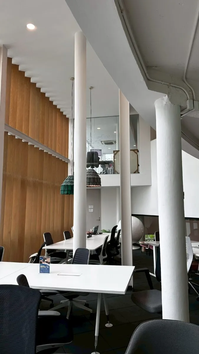 Double-height atrium with wood-slat wall and pendant lights